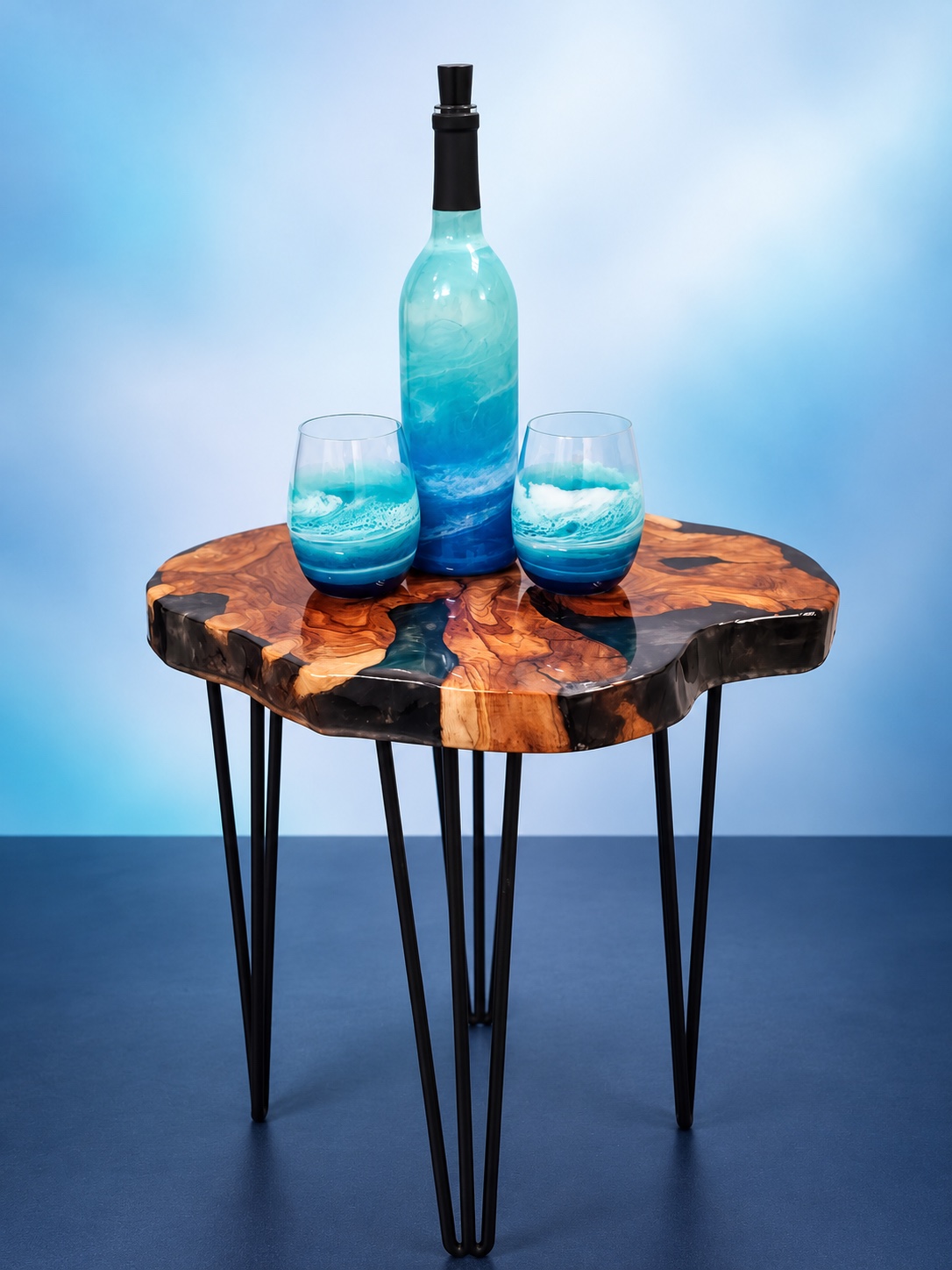 Turquoise ocean resin bottle and two glasses on a live-edge table