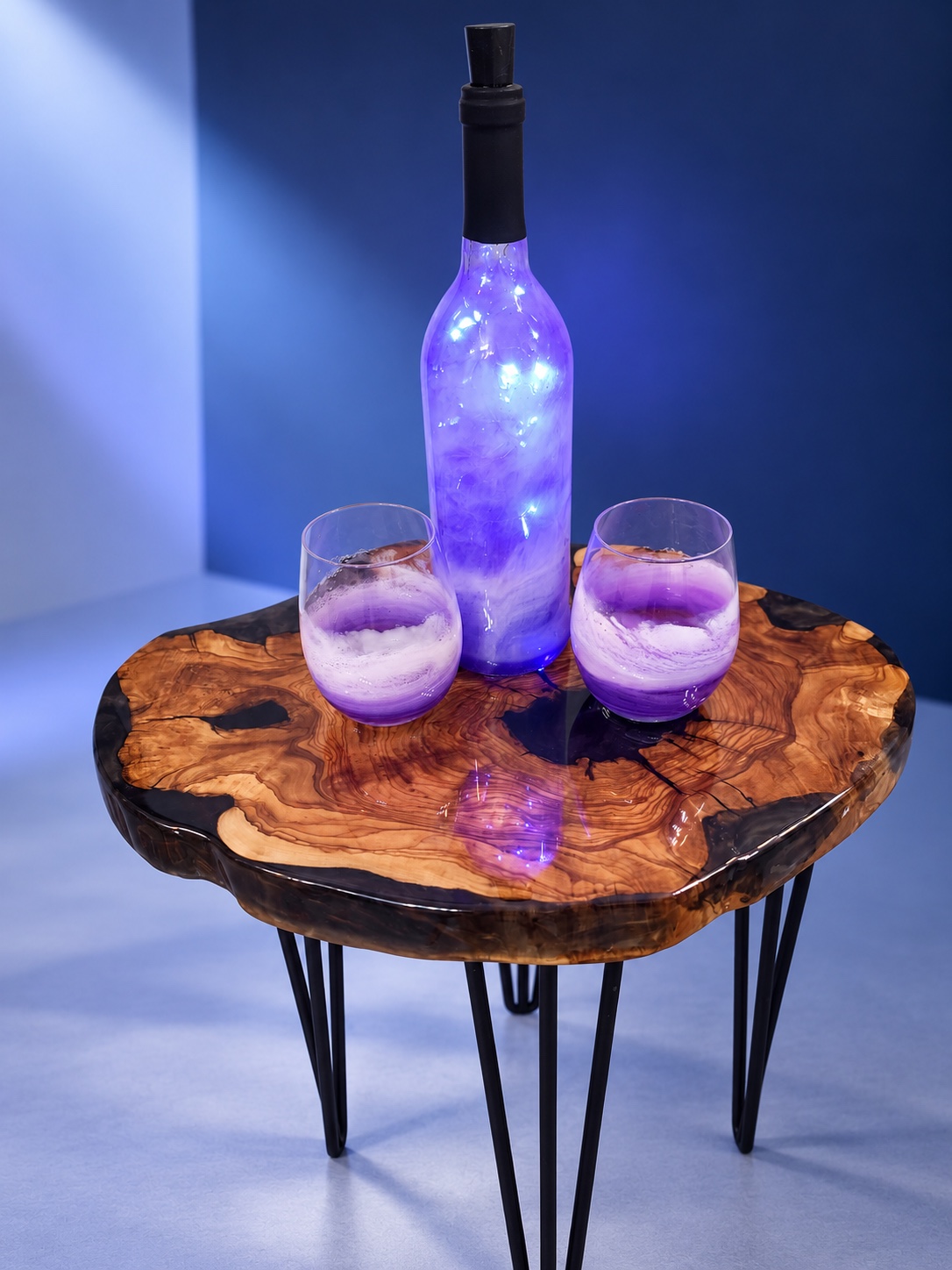 Illuminated violet resin bottle and two purple ocean glasses